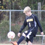 A young boy playing soccer on a field.