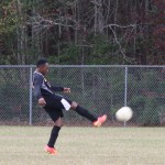 A young boy playing soccer on a field.