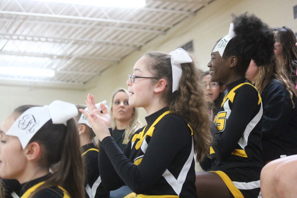 Cheerleaders performing at a basketball game.