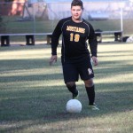 A young boy playing soccer on a field.