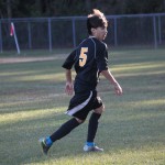 A young boy playing soccer on a field.