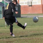 A young boy playing soccer on a field.