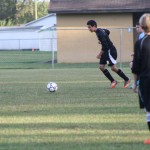 A young boy playing soccer on a field.