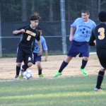 young boys playing soccer on a field.