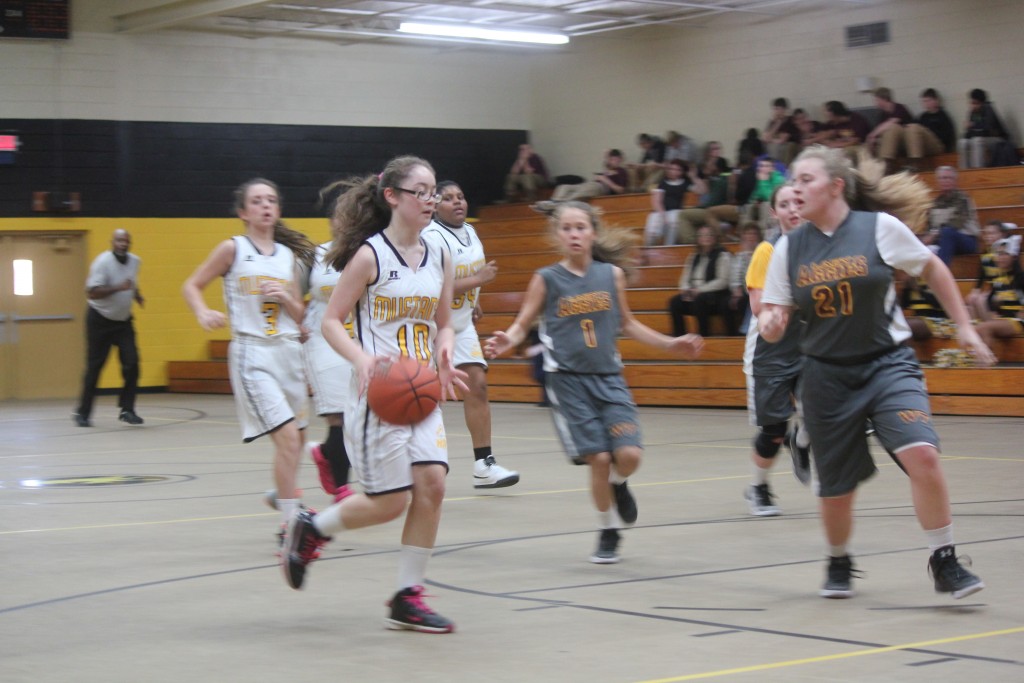 Young female basketball players sprinting down court during intense game.