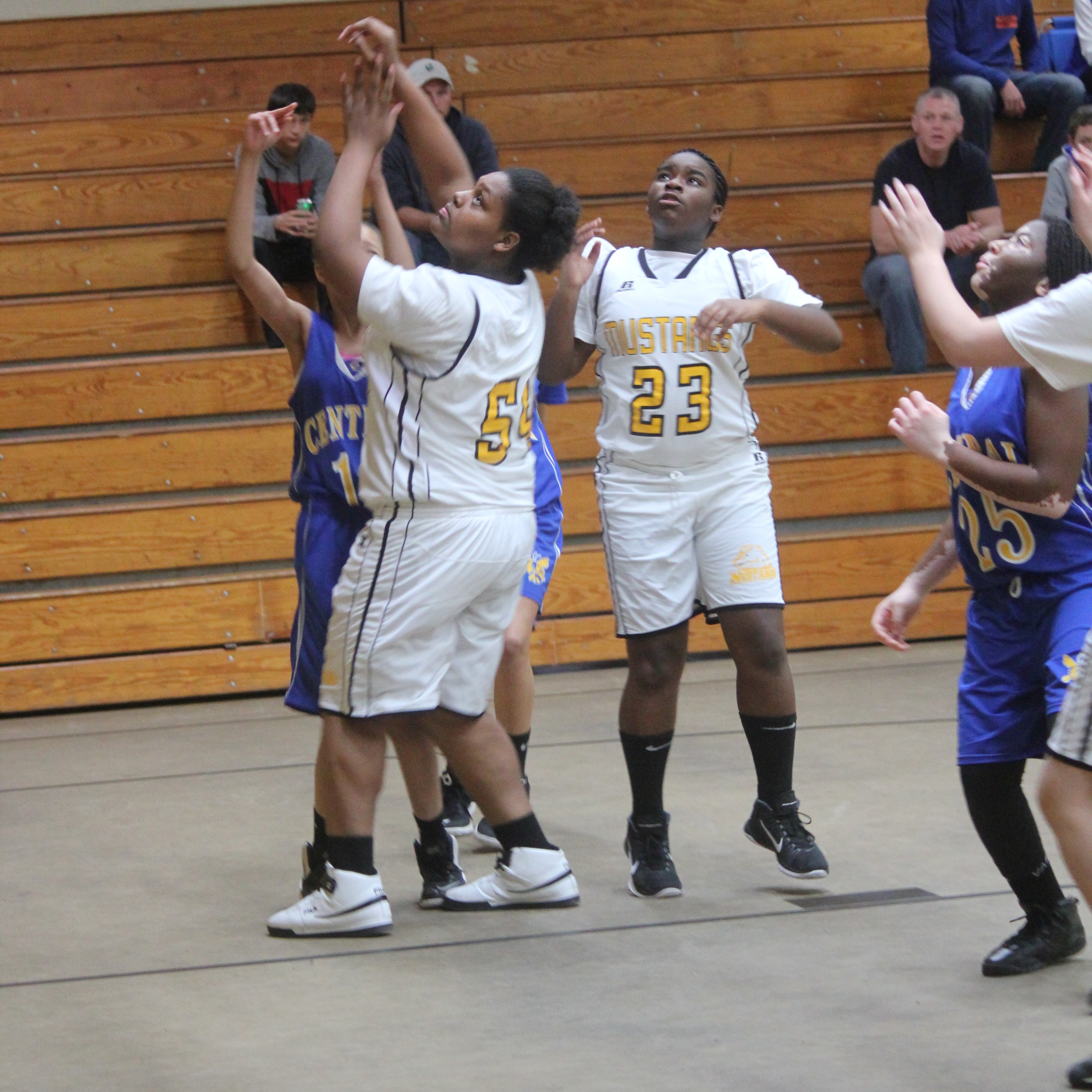 Young girls playing basketball on a court, dribbling and shooting hoops, enjoying a friendly game together.