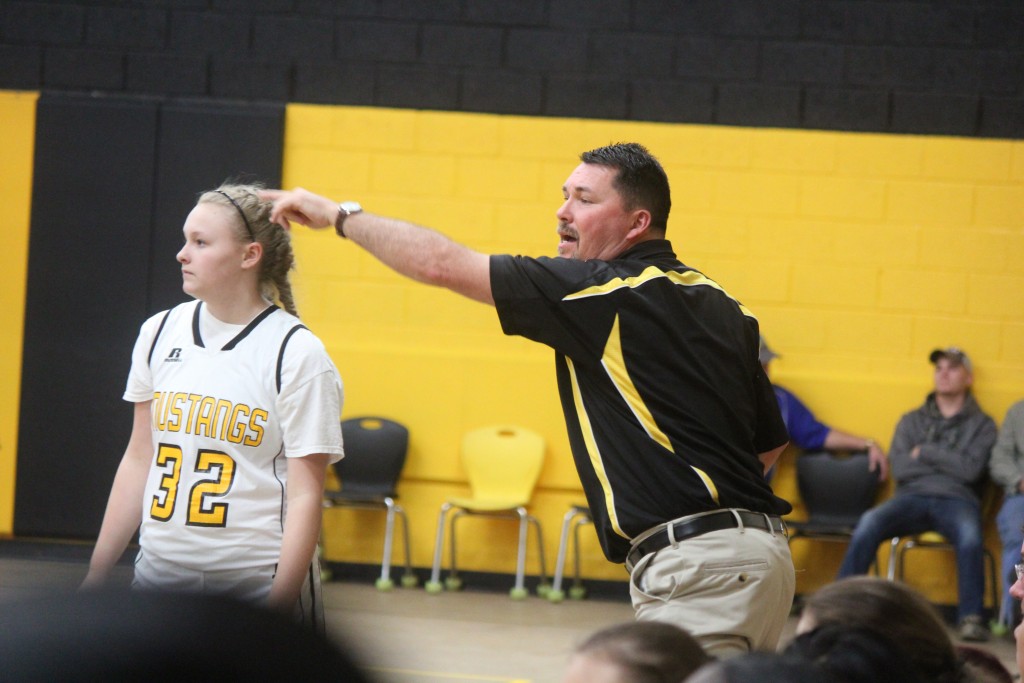 A man discussing with a girl on a basketball court.