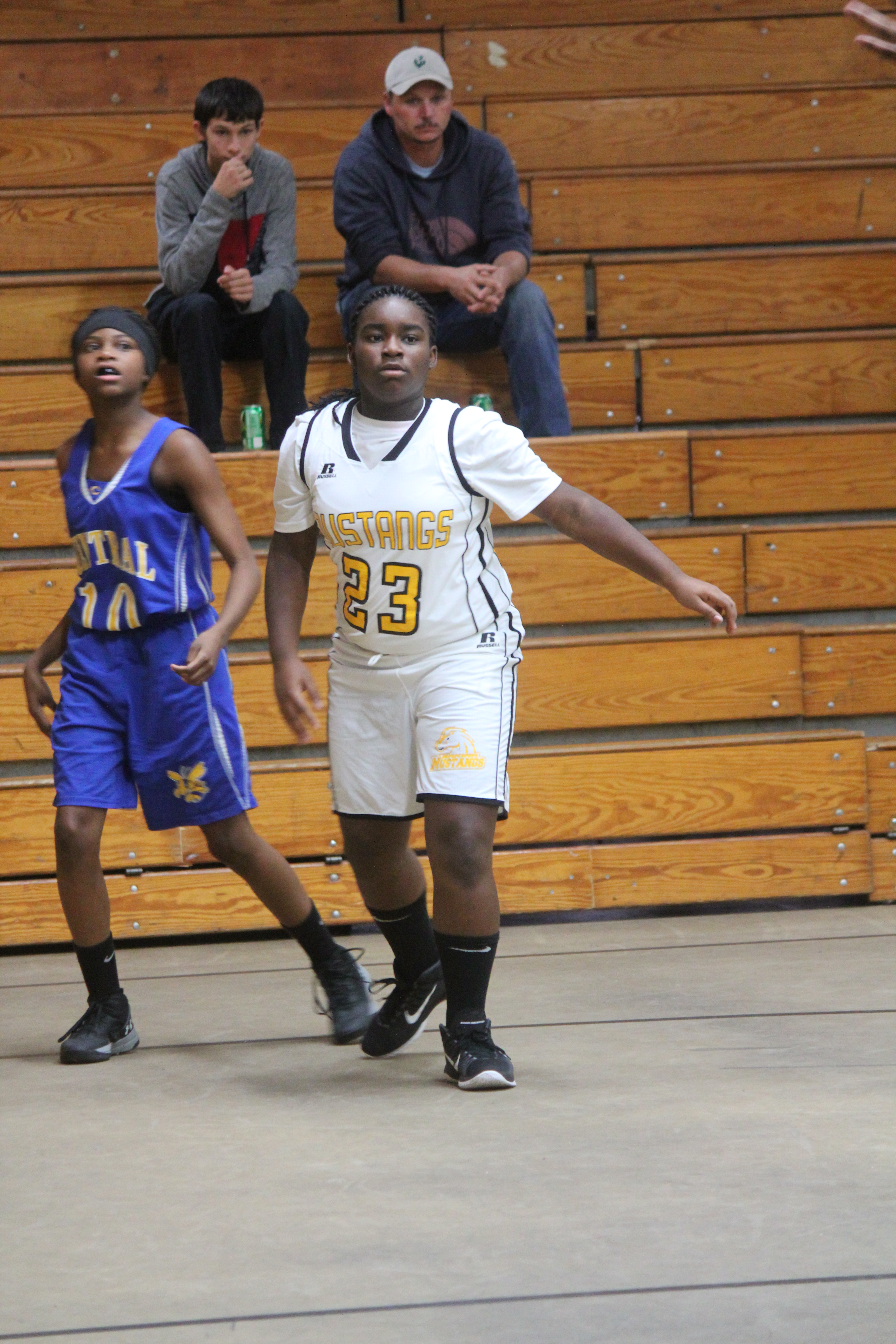 Young female basketball players sprinting down court during intense game.