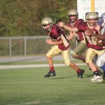 A football player running with the ball on the field