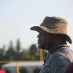 A man wearing a hat and shirt in a field.