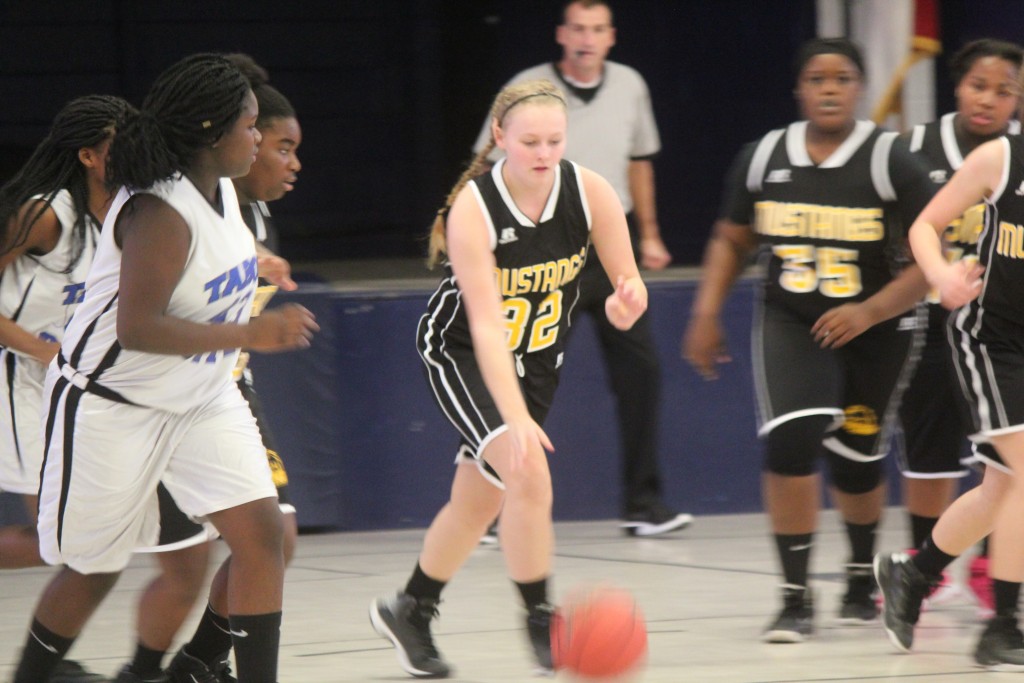 Young female basketball players in action during a game on the court.