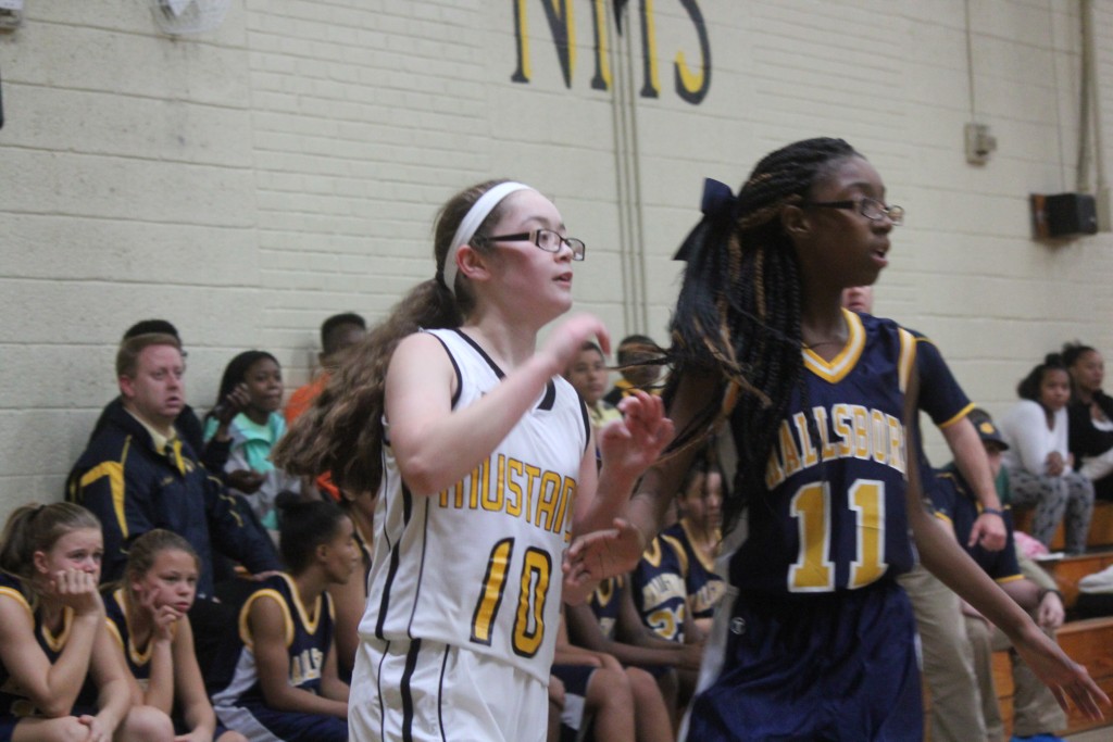 A group of young female basketball players in action at the Allisonville basketball game.