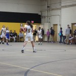 Young female basketball players dribbling and shooting on the court during a game.