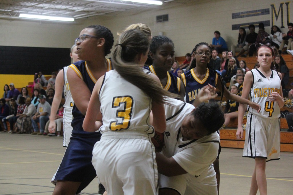 Young female basketball players in action during a game on the court.