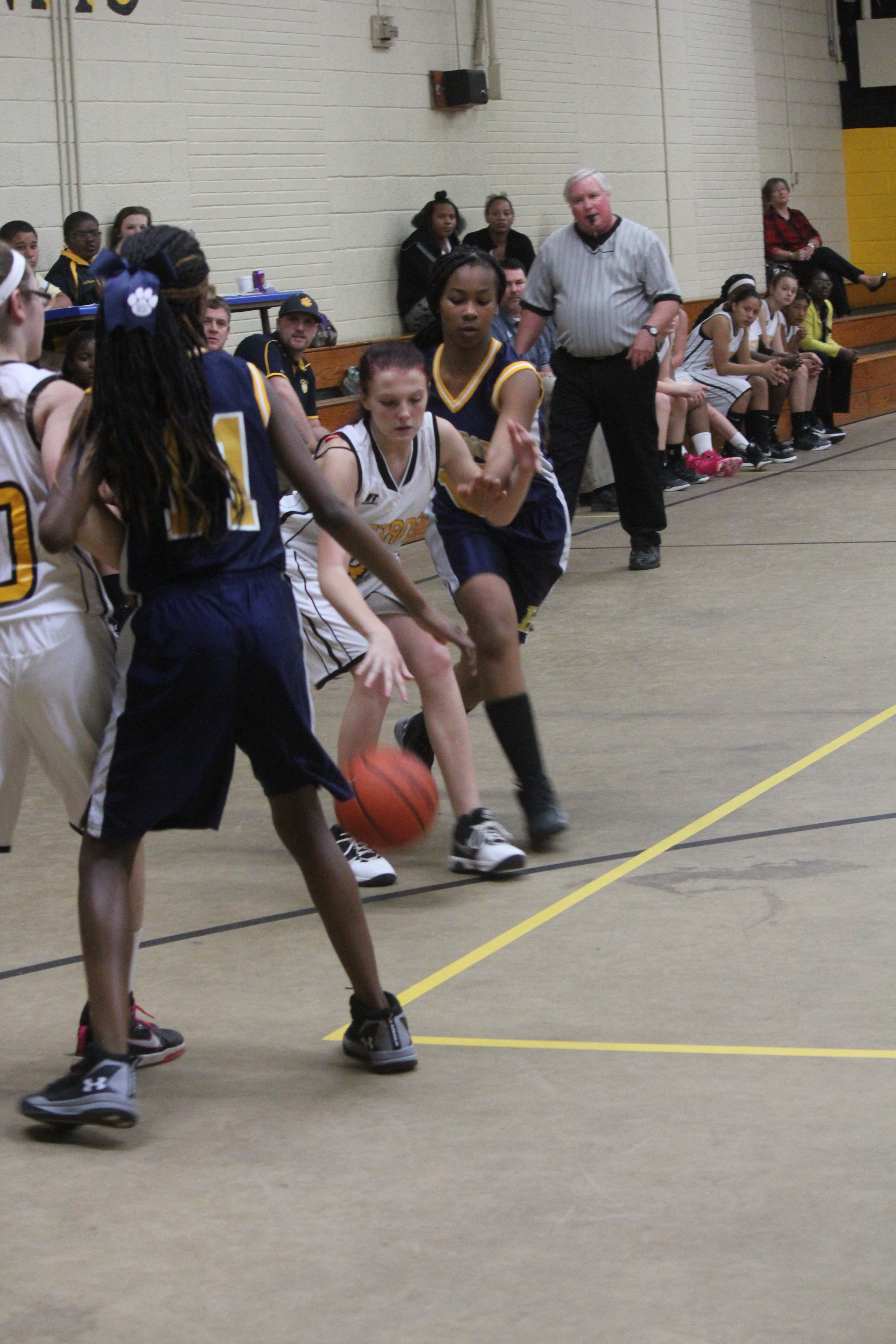 Young female basketball players in action during a game on the court.