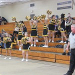 Cheerleaders in colorful uniforms perform energetic routines on the basketball court.