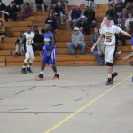 Young men playing basketball in a gym.