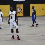 A basketball player standing on the court with teammates.