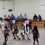 Girls basketball team playing in gymnasium.