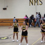 Cheerleaders in action at NMSHS basketball game, showcasing their spirit and energy.