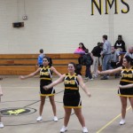 Cheerleaders in action at NMSHS basketball game, showcasing their spirit and energy.