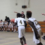  A group of boys playing basketball in a gym.