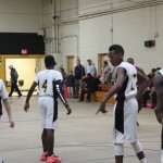 Young men playing basketball in a gym, dribbling and shooting hoops, having fun and staying active.