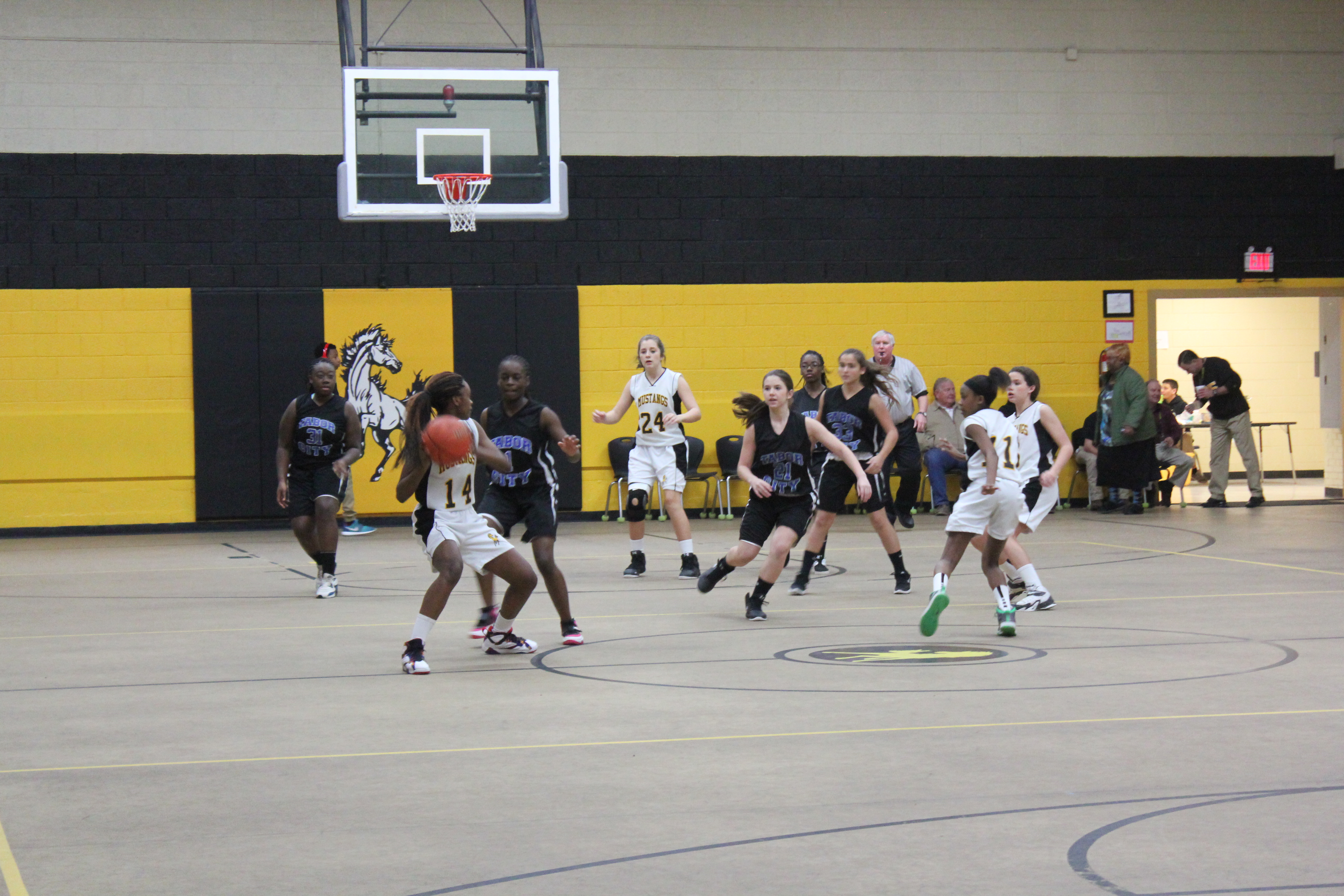 Girls basketball team playing in gymnasium.