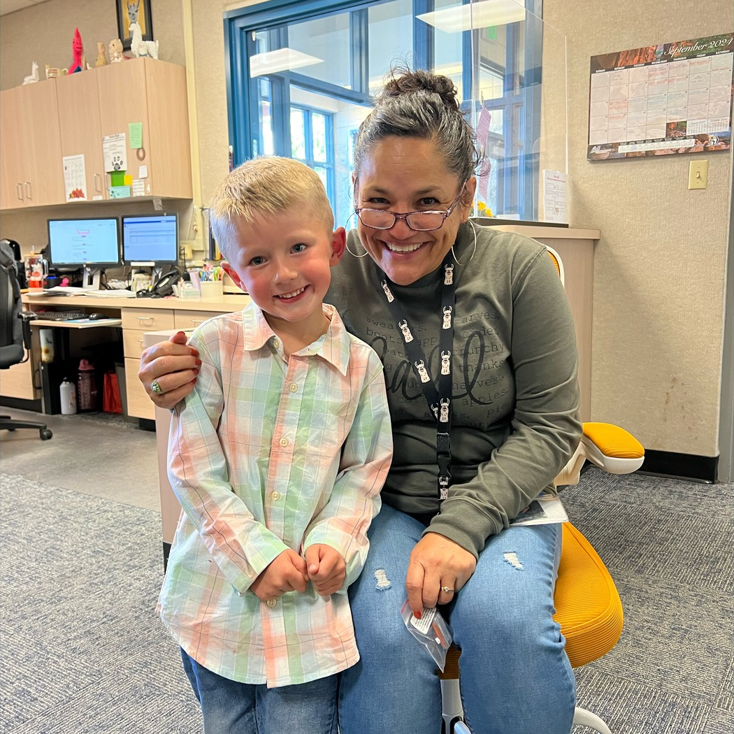 Mrs. Doerr , Secretary Teacher Smiling for Golden Chair Picture