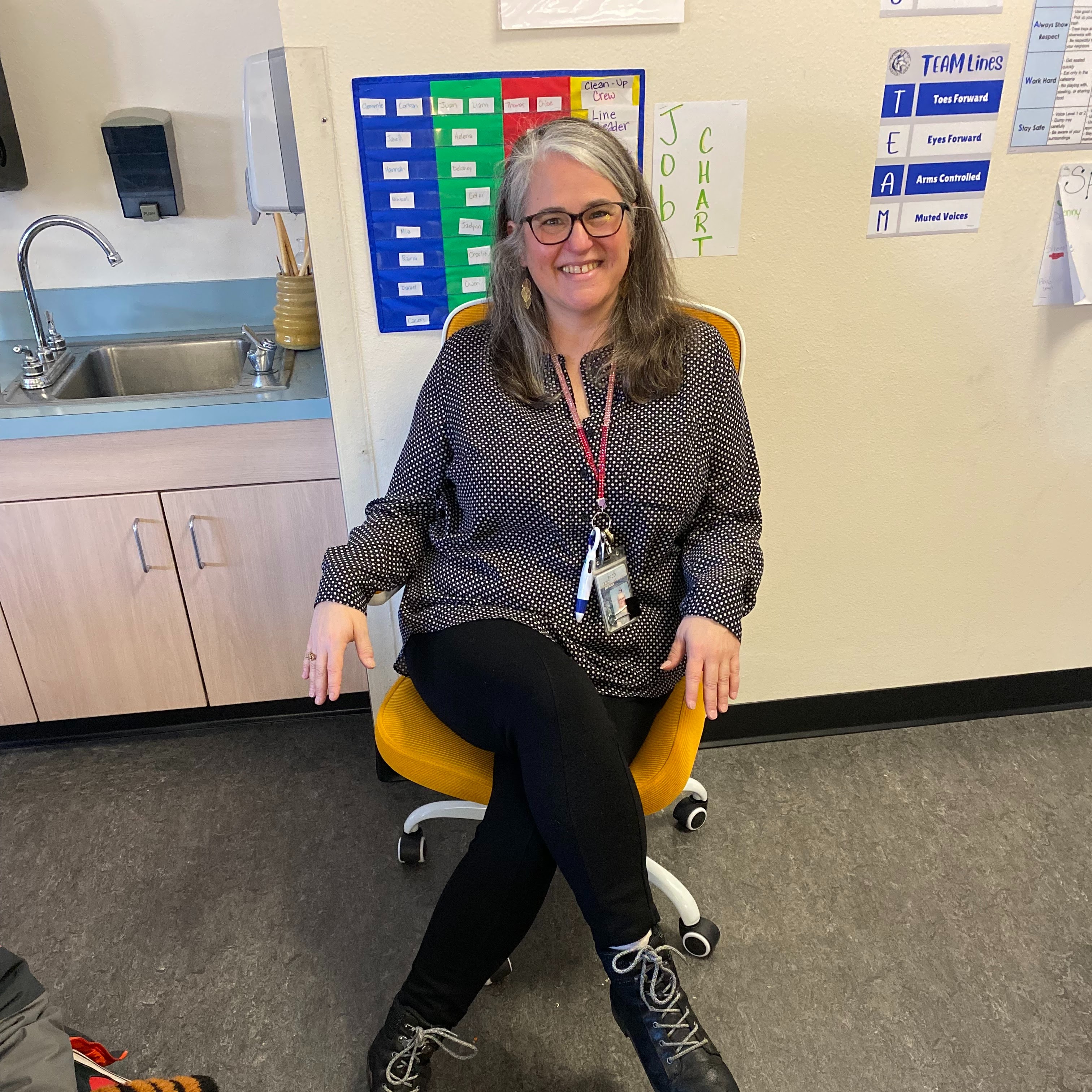 Teacher sitting in golden chair  posing.