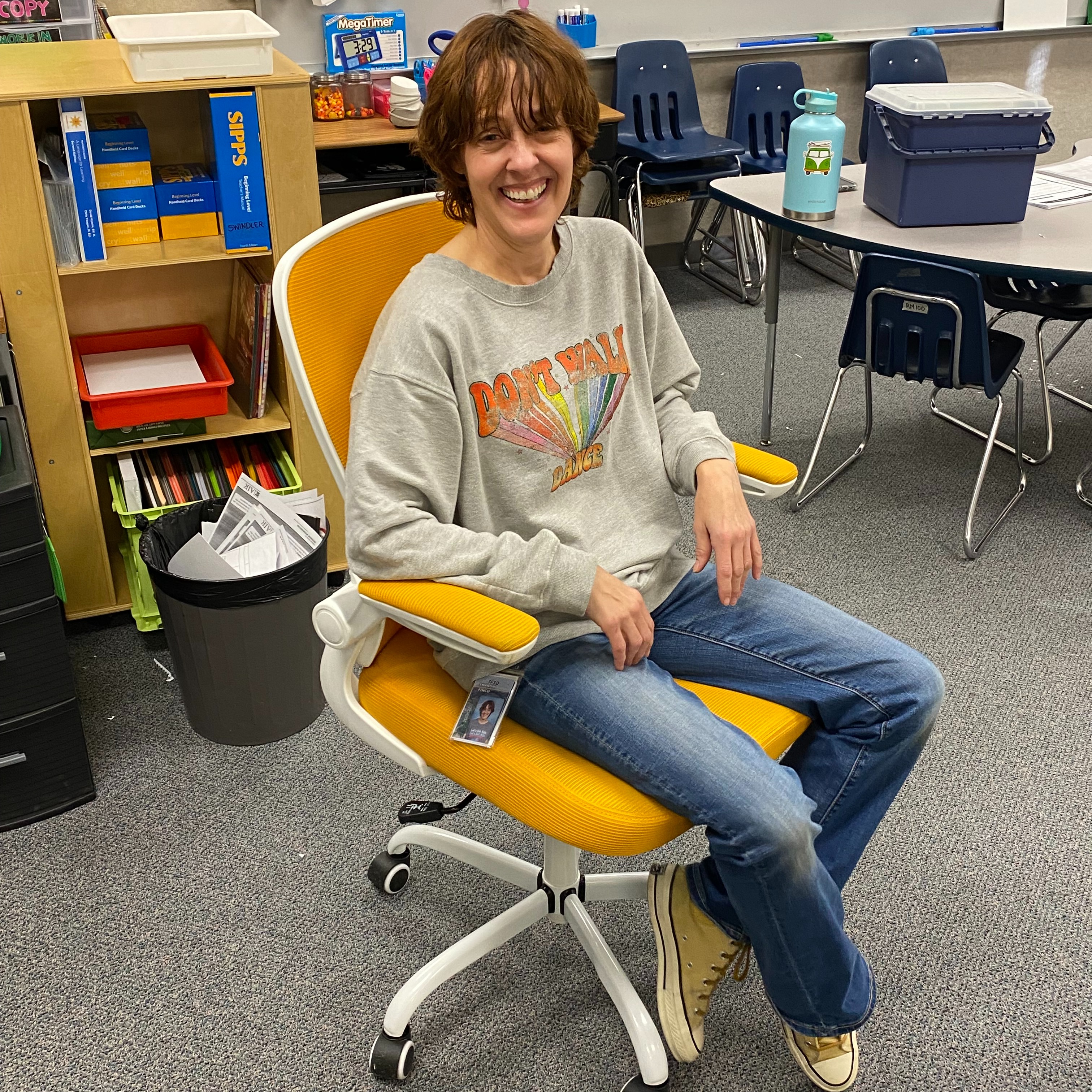 Teacher sitting in golden chair  posing.