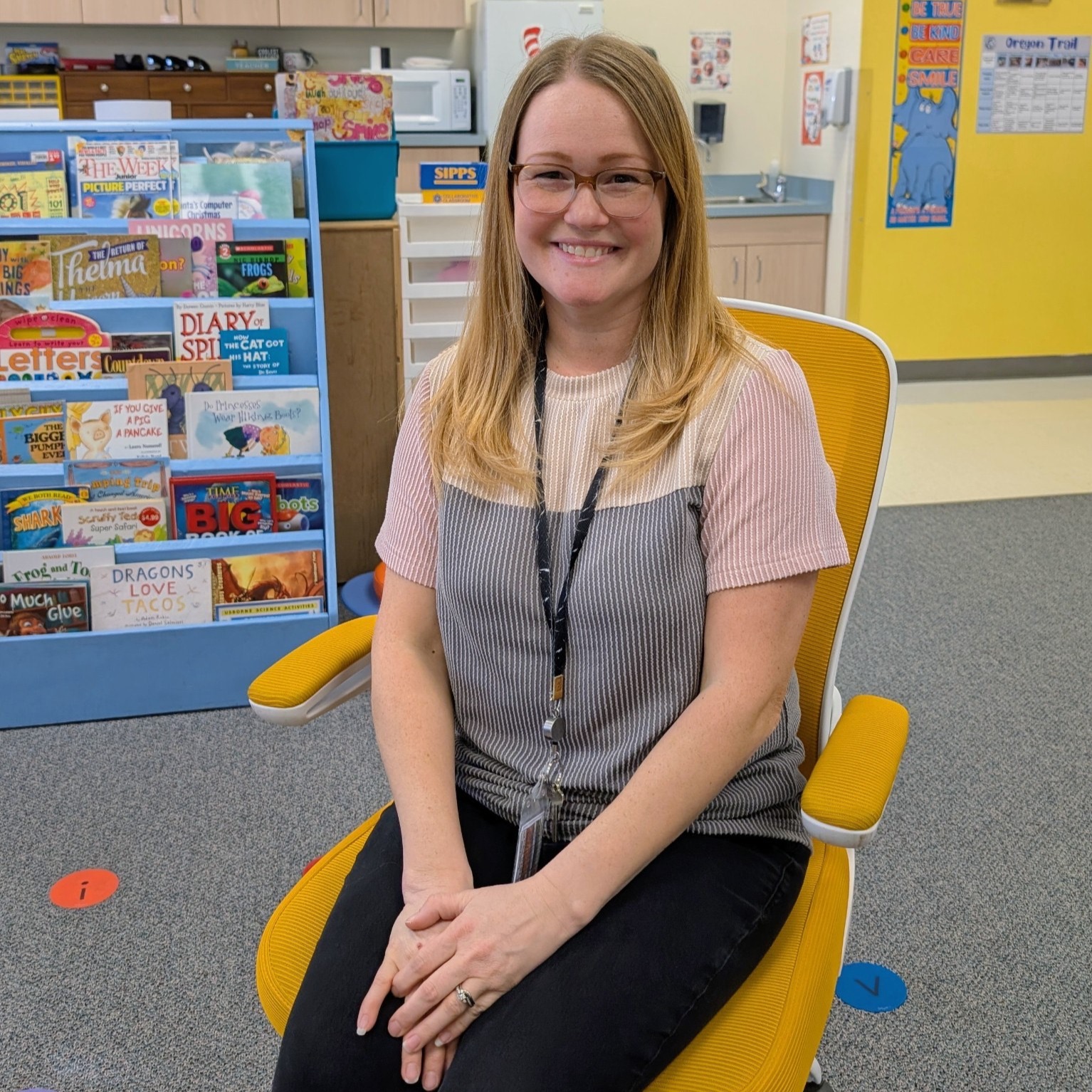 Teacher sitting in golden chair  posing.