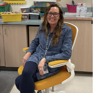 Teacher sitting in golden chair  posing.