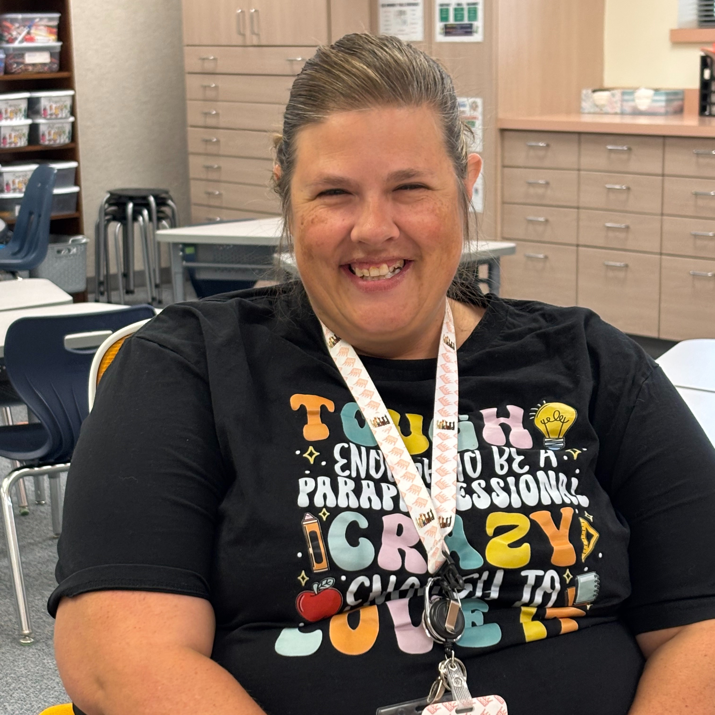 Teacher sitting in golden chair smiling