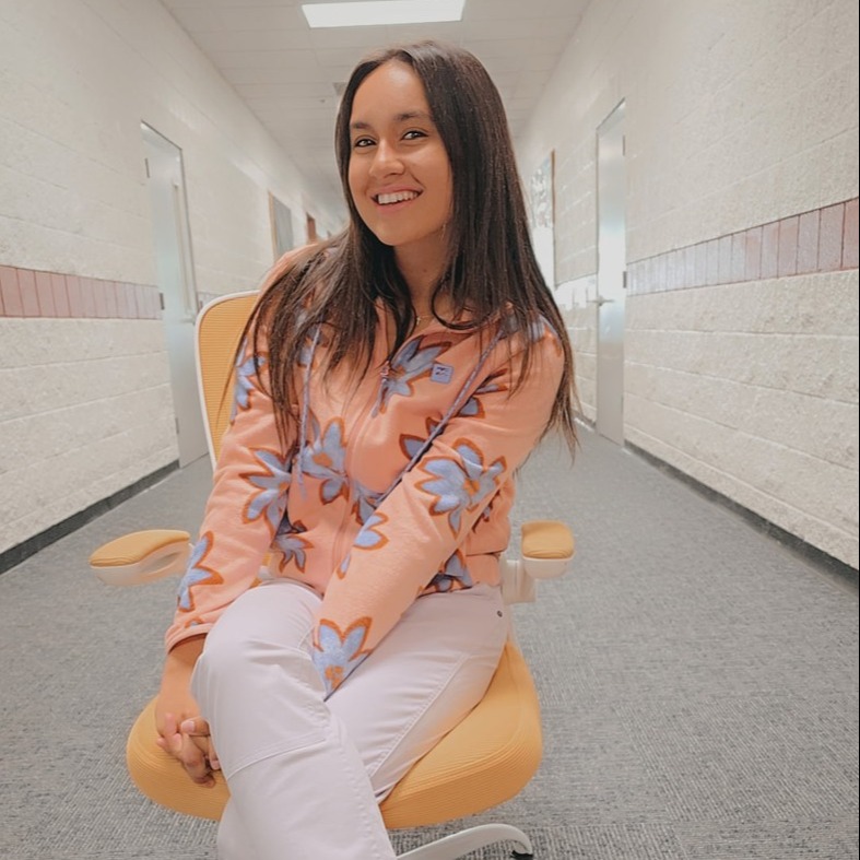 Teacher sitting in golden chair  posing.