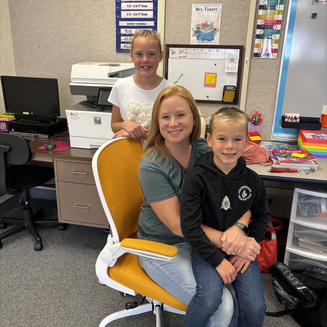 Teacher sitting in golden chair posing.