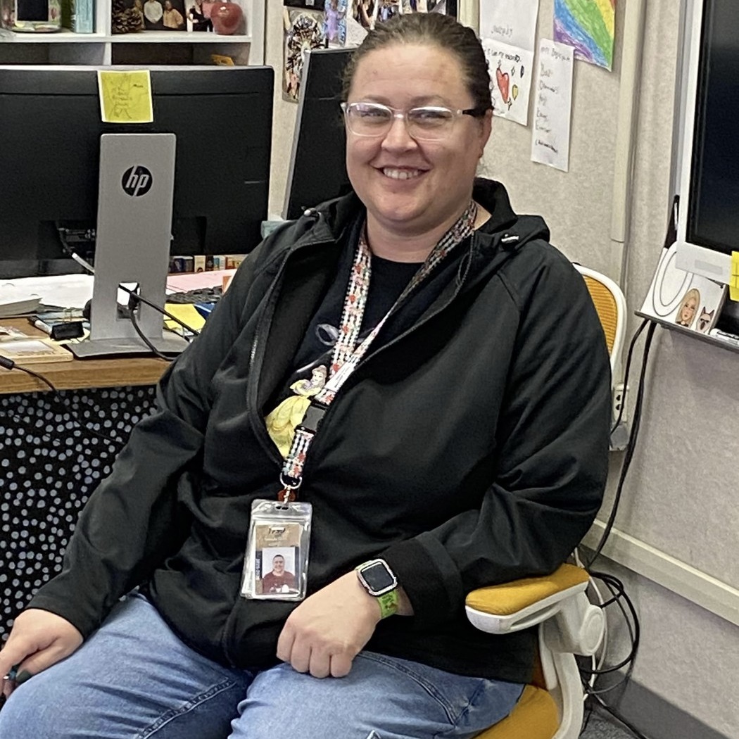 Teacher sitting in golden chair posing.