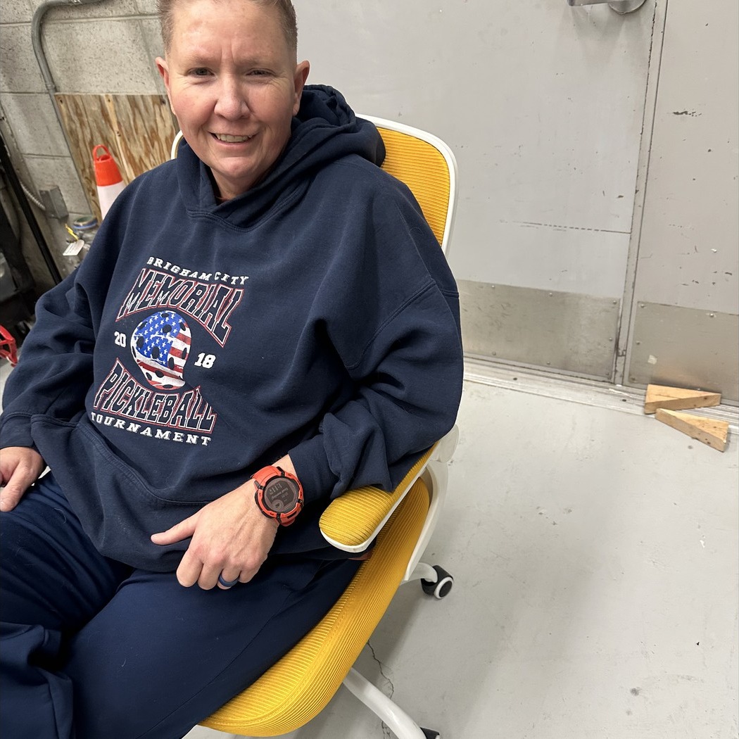 Teacher sitting in golden chair posing.