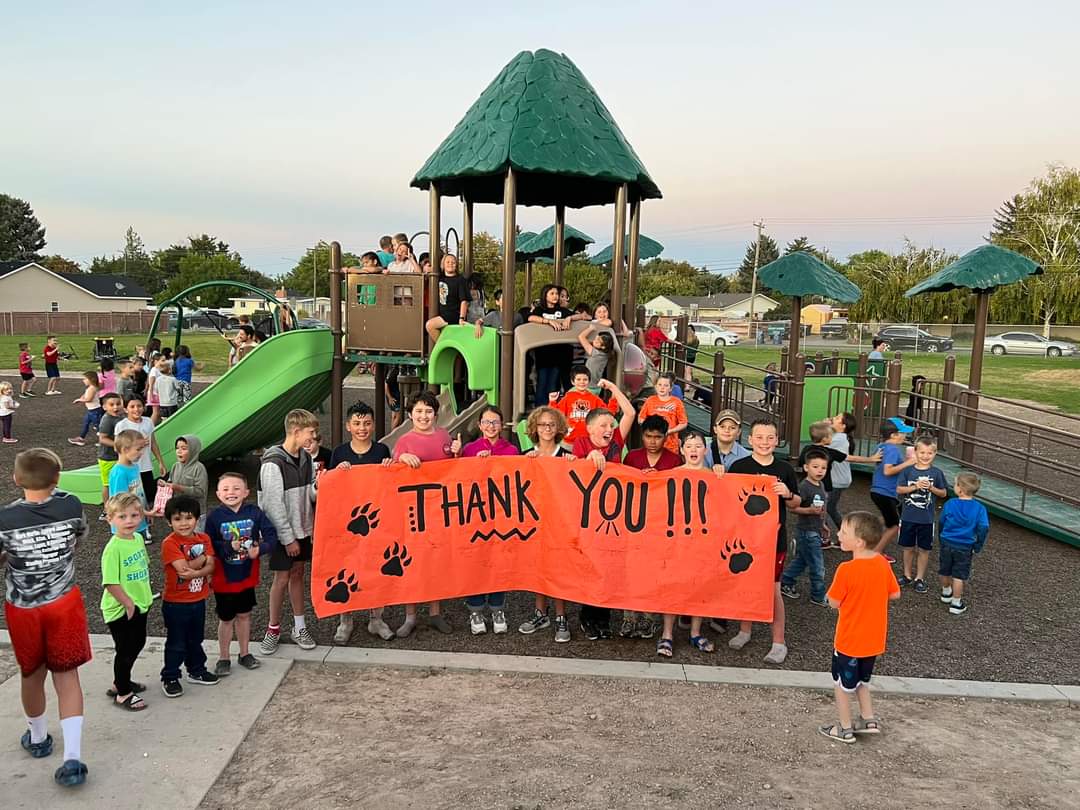 Students holding up a Thank You banner at the Grand Opening of Sawtooth's Adaptive Playground