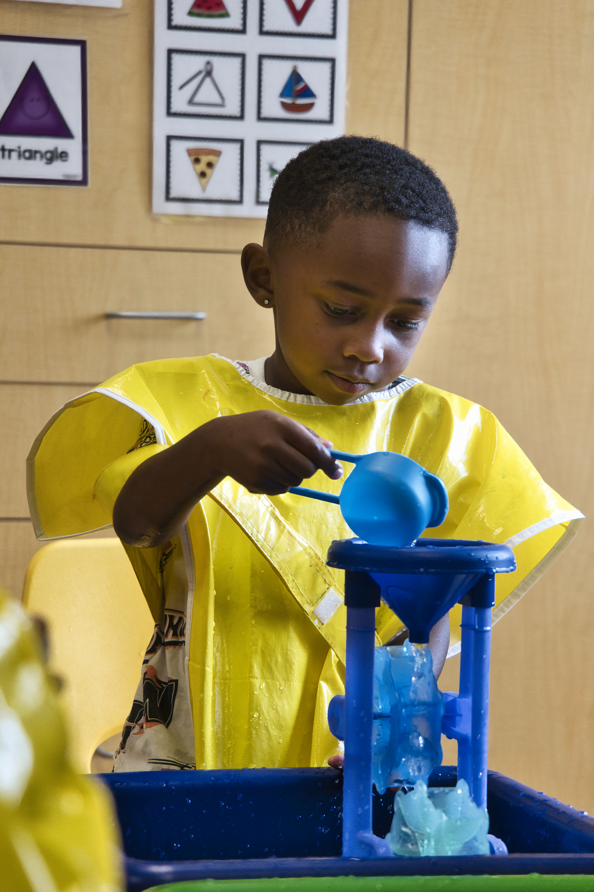 Student pouring fluid through funnel in class