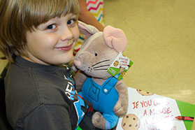 kid holding stuffed animal smiling to camera