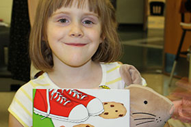 girl holding a book and smiling to camera