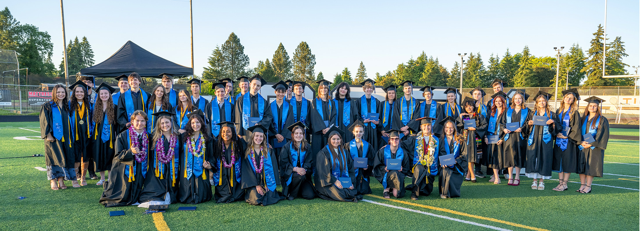 River HomeLink graduates in three rows outside