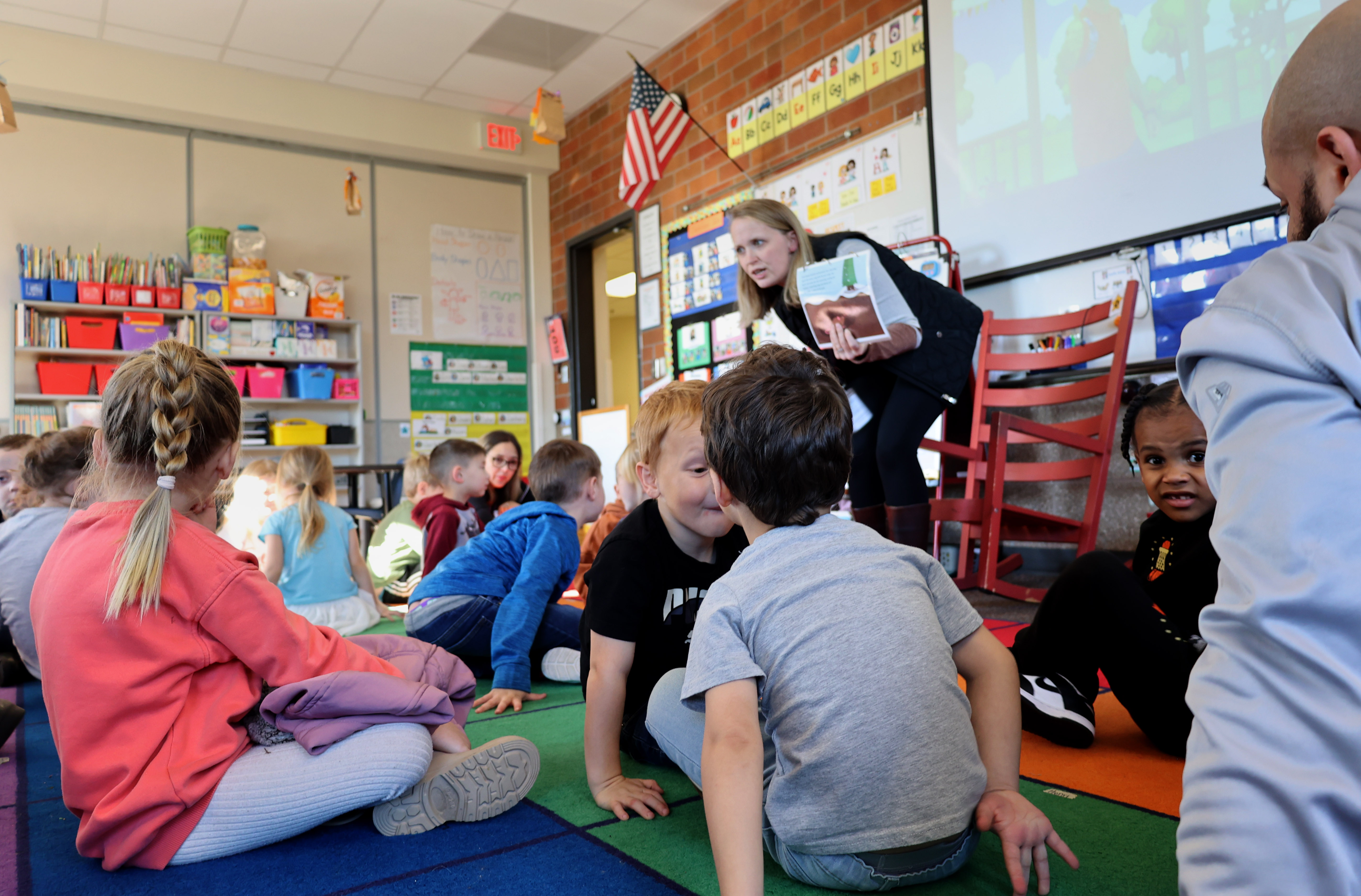 teacher reads to a group of Transitional Kindergarteners