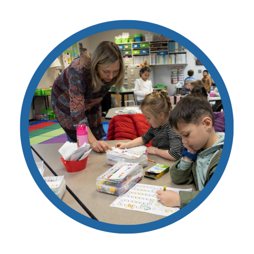 A teacher works with students in a classroom