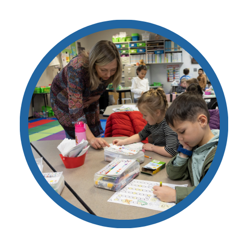 A teacher works with students in a classroom
