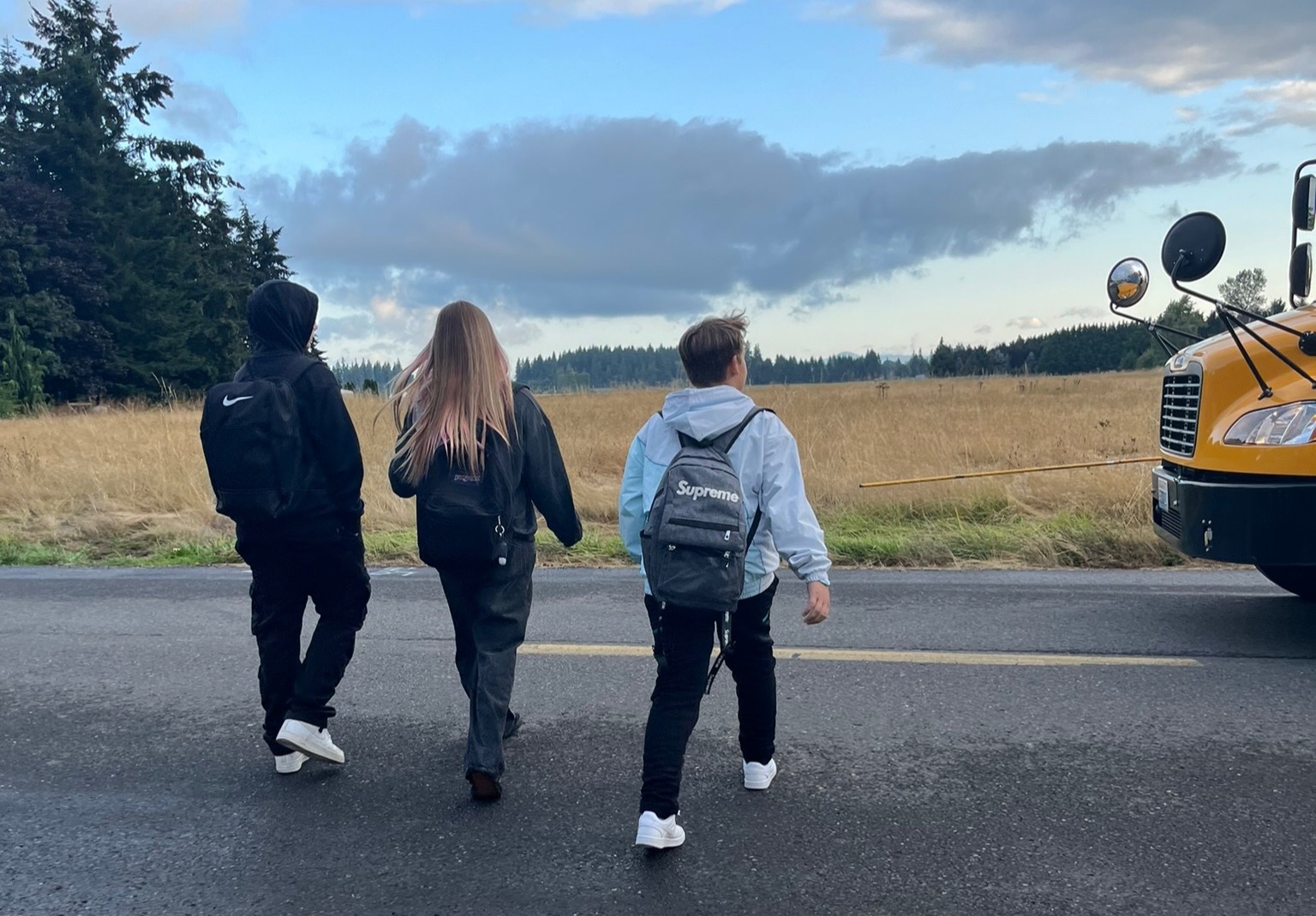 Students prepare to board an arriving school bus