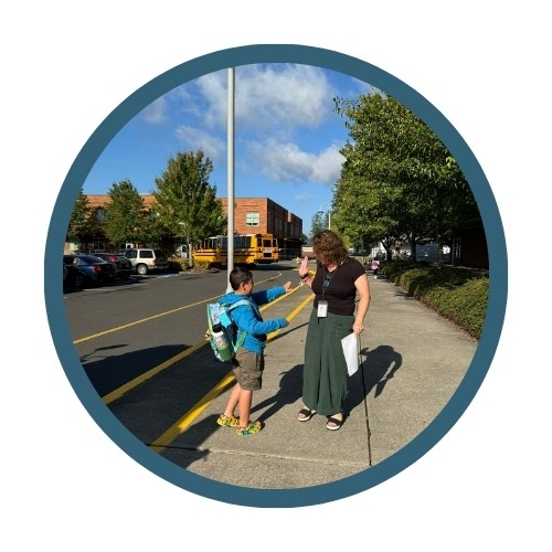 A student high fives a staff member