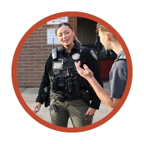 A school resource officer talks with a student