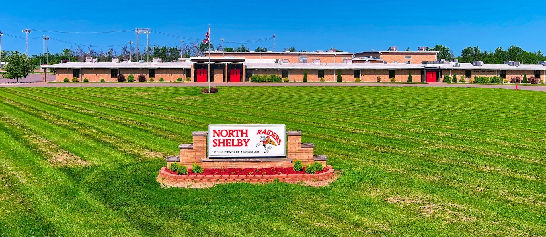 front of north shelby building with sign and fresh cut grass